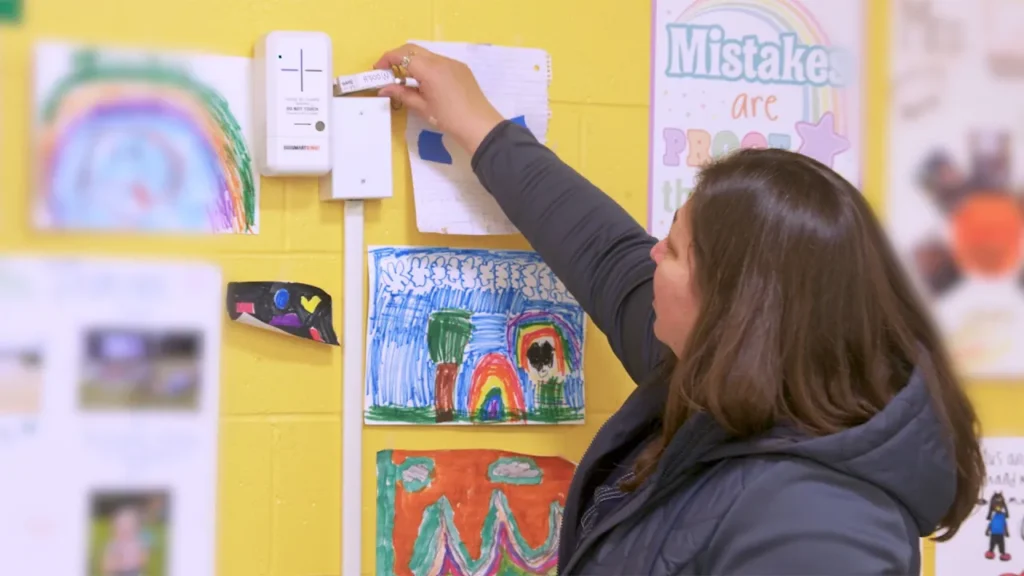 Patricia Fabian checks an indoor air quality sensor in an elementary school classroom